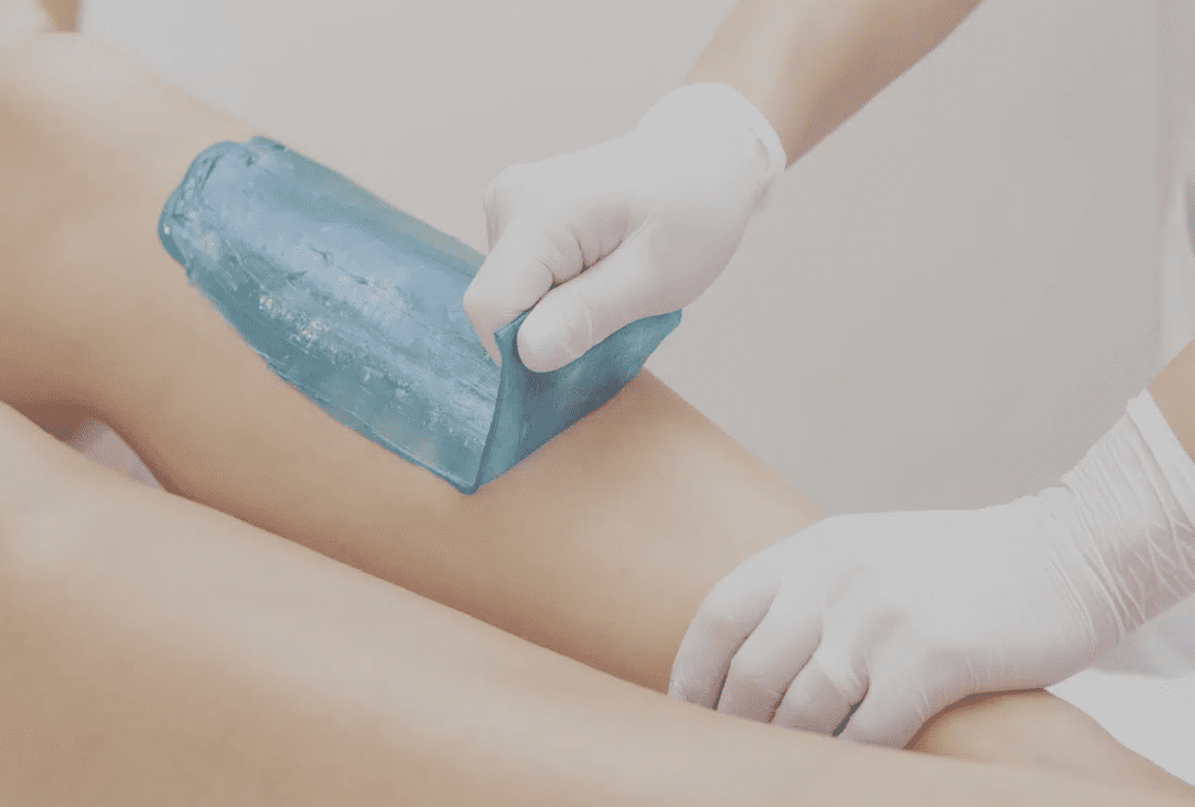 A person is waxing their legs with a blue block.